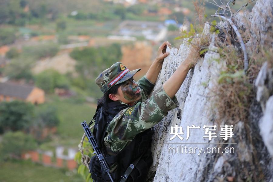 Female soldier of armed police force climbs cliff barehanded