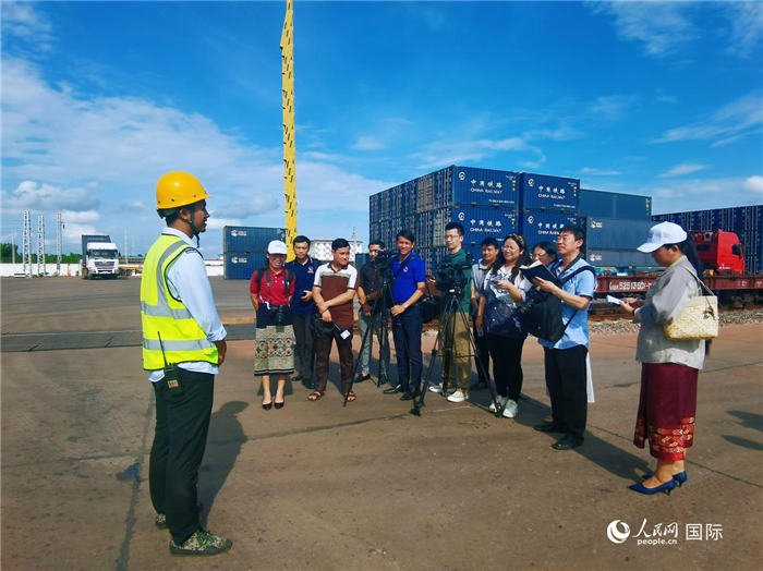Journalists from People's Daily and Lao media conduct a joint interview at the Vientiane South Railway Station. (People's Daily Online/Du Mingming)