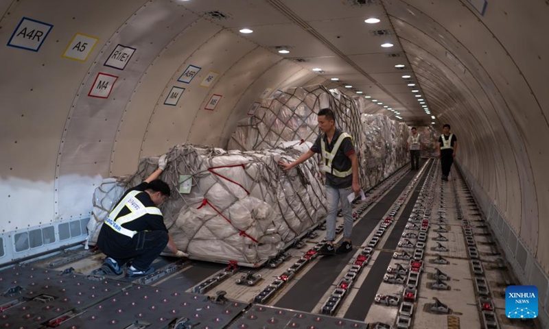 Staff members load the cargo onto an airplane at the Ezhou Huahu Airport in Ezhou, central China's Hubei Province, May 25, 2024. The Ezhou Huahu Airport, an all-cargo hub airport starting operations in July 2022, is now running 48 domestic routes and 17 international routes. The airport owns a 750,000-square meter cargo transfer center with parcel sorting lines adding up to 52 kilometers, and its international throughput has exceeded 80,000 tonnes. (Photo:Xinhua)