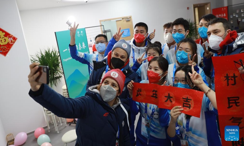 Delegation members of Serbia and volunteers pose for selfies at the Olympic Village for the Beijing 2022 Winter Olympics in Yanqing District of Beijing, capital of China, Jan. 31, 2022. Delegation members and volunteers celebrated the Chinese Lunar New Year, or the Year of Tiger at the Olympic Village on Monday. (Photo by Xiao Shaowen/Xinhua)