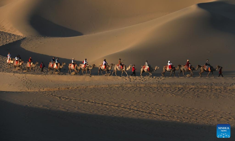Tourist ride camels at the Mingshashan and the Crescent Lake, an oasis scenic spot in the Gobi Desert in Dunhuang, northwest China's Gansu Province, June 9, 2024. China saw 110 million domestic tourist trips made during the three-day Dragon Boat Festival holiday, up 6.3 percent from the same period last year, the Ministry of Culture and Tourism said Monday. (Photo: Xinhua)