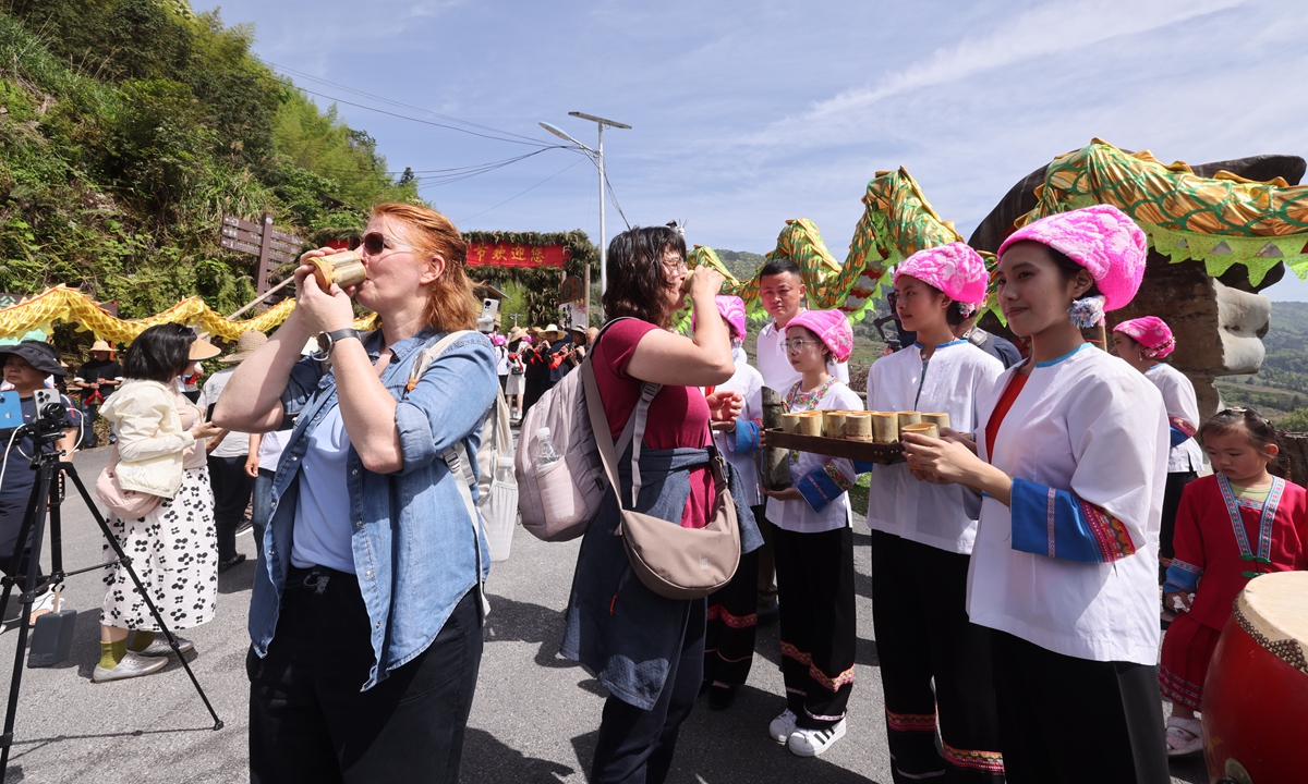 Foreign visitors taste local drinks during the Terraced Fields Plowing Festival held in Guilin, South China's Guangxi Zhuang Autonomous Region. Photo: Courtesy of He Chengxi