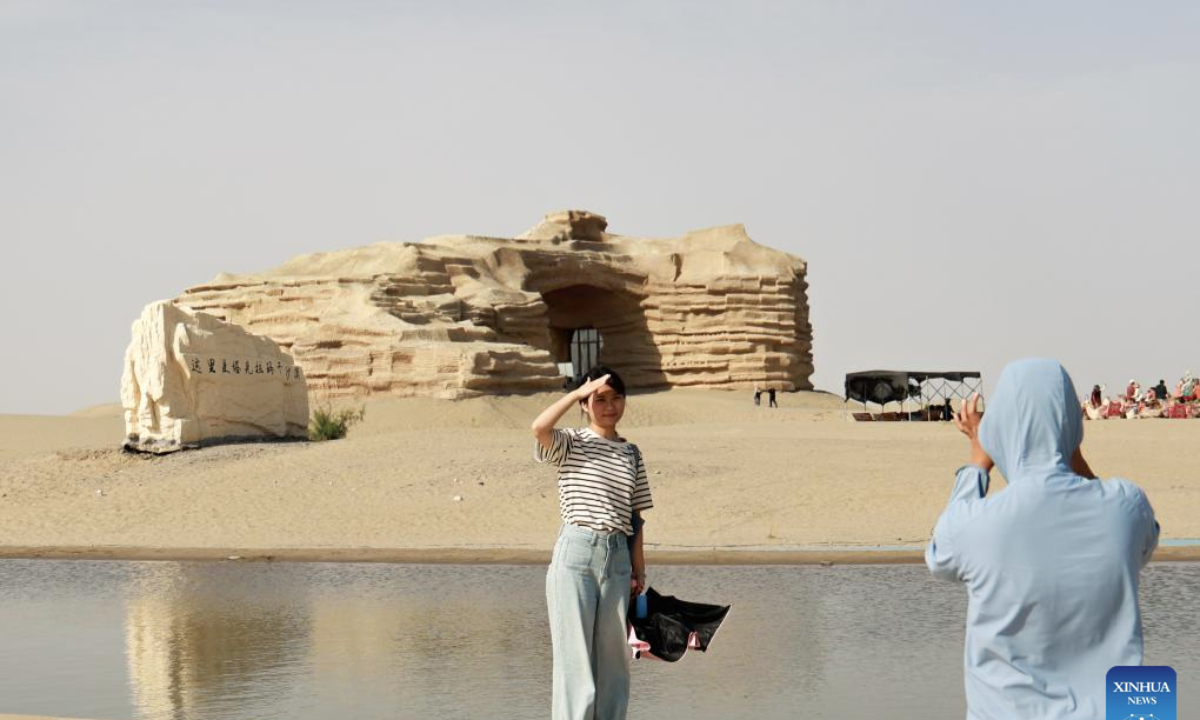 Tourists take photos at the desert gate scenic area in Alaer, northwest China's Xinjiang Uygur Autonomous Region, Aug. 12, 2025. The desert gate scenic area, covering an area of 14 hectares, receives an average of 600,000 visits annually. (Xinhua/Liu Jiaqi)