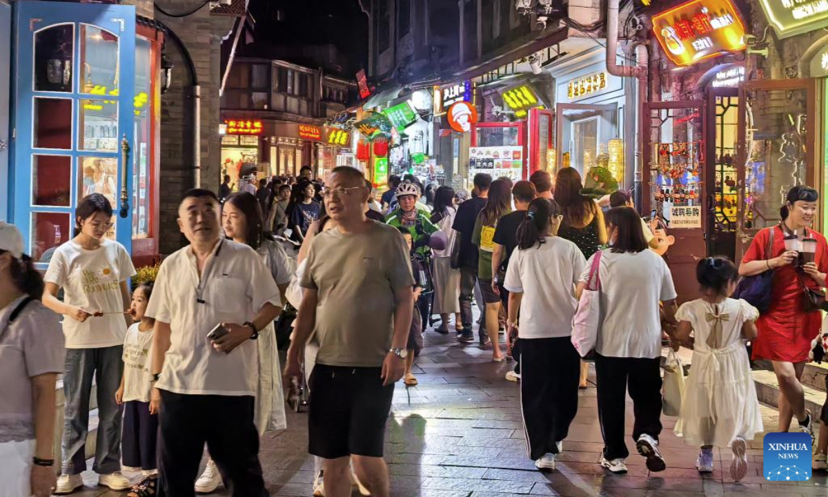 People walk at a pedestrian street near Shichahai scenic area in Beijing, capital of China, July 30, 2025. Beijing has vigorously developed its night economy since the beginning of this summer, featuring local cuisine, outdoor films, music festivals, and night markets. (Xinhua/Li Xin)