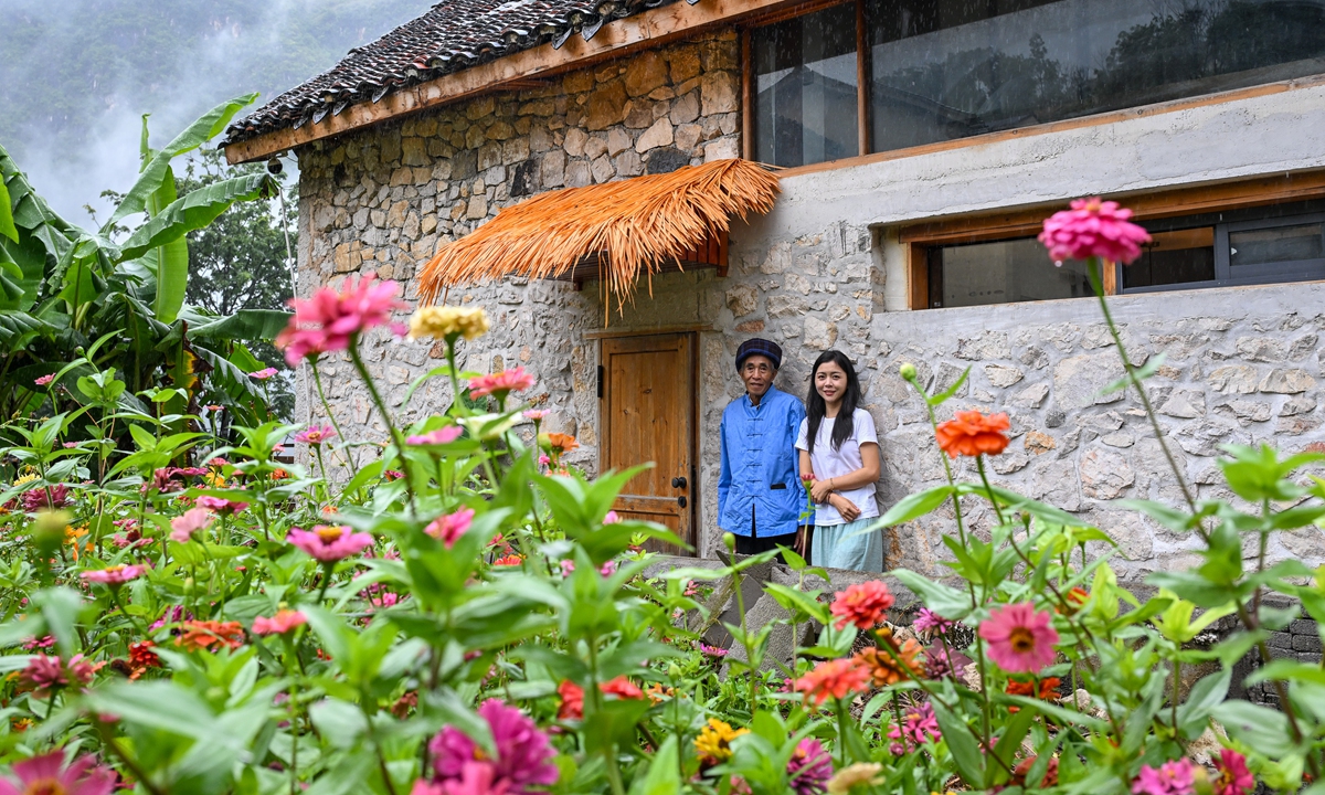 Liang Shaoyu, a villager from Xiaohuajiang village, takes a photo with Cao Hui who rented his house for homestay renovation on September 26, 2025. Photo: Chen Tao/GT